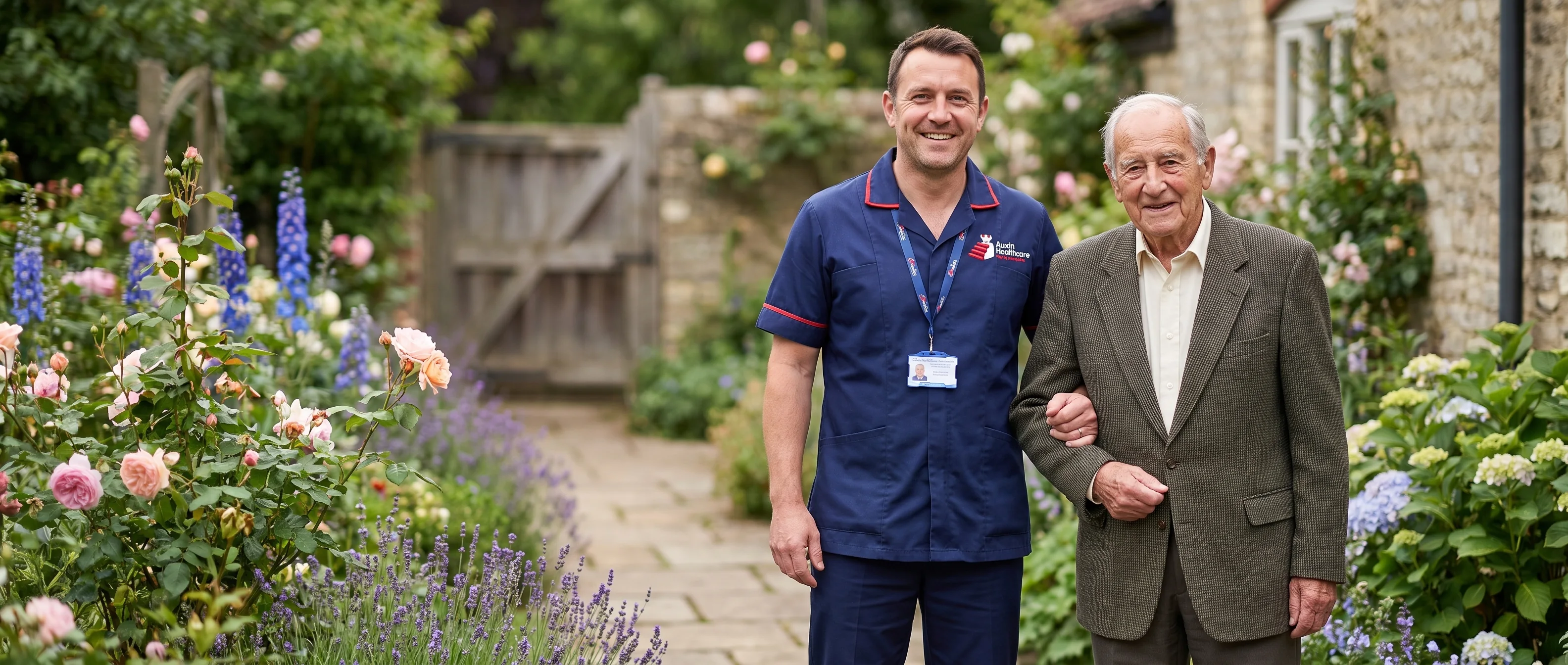 Auxin carer walking with an older man in his garden during a home care visit in Spalding