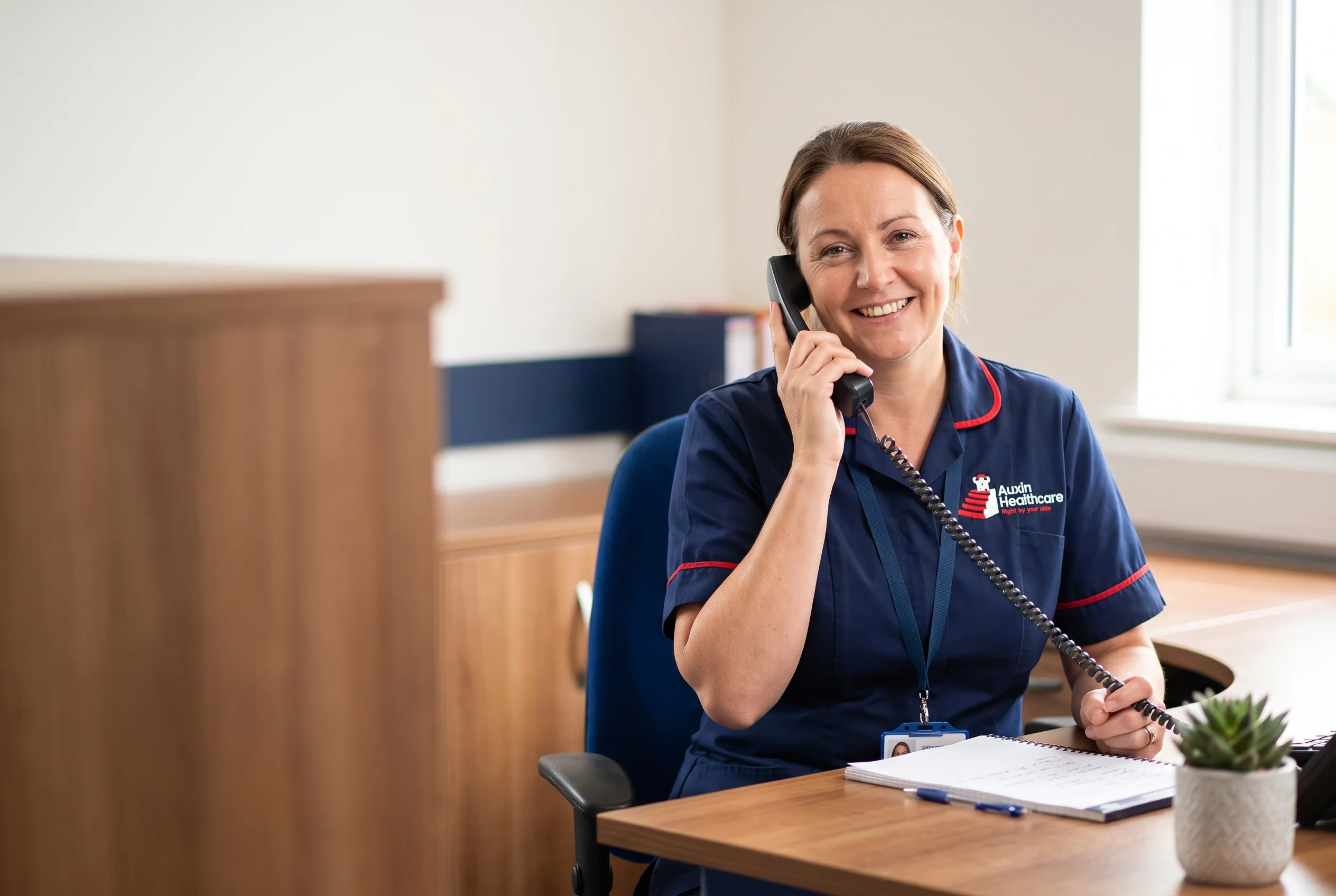 Friendly Auxin care coordinator answering a home care enquiry by phone at the Spalding office